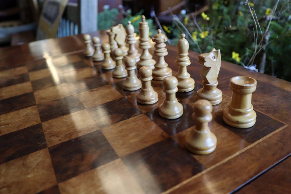 A George III style walnut sofa / games table with sliding reversible top, includes chess and backgammon pieces, width 94cm depth 60cm